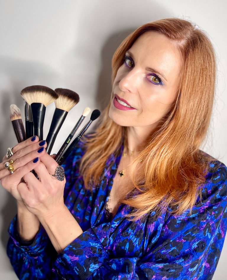 Experte en conseil en image tenant des pinceaux de maquillage, spécialisée en colorimétrie, visagisme et style adapté à la morphologie