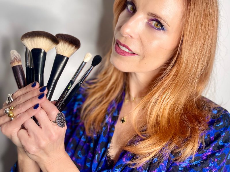 Experte en conseil en image tenant des pinceaux de maquillage, spécialisée en colorimétrie, visagisme et style adapté à la morphologie