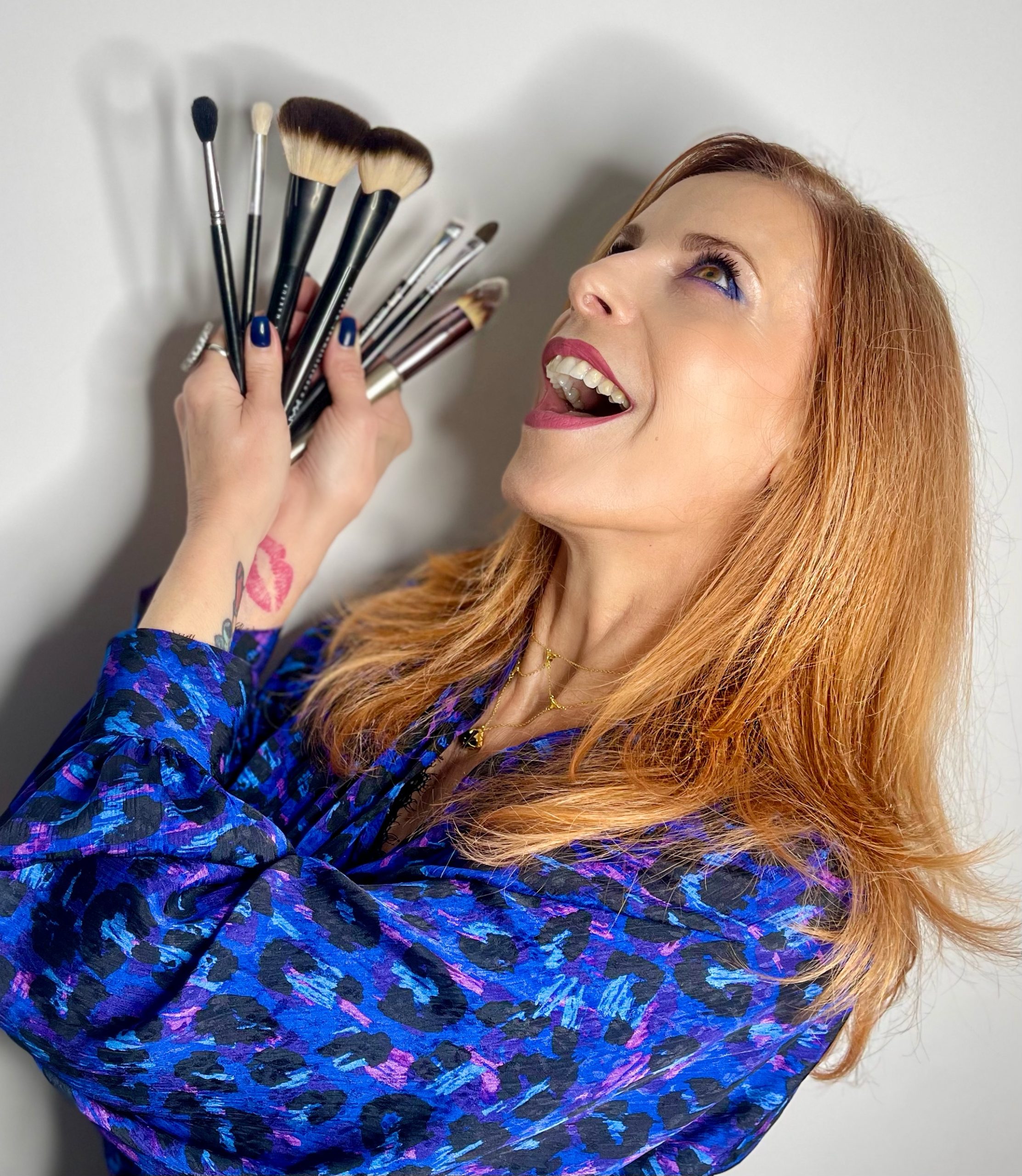 Experte en conseil en image tenant des pinceaux de maquillage, spécialisée en colorimétrie, visagisme et style adapté à la morphologie